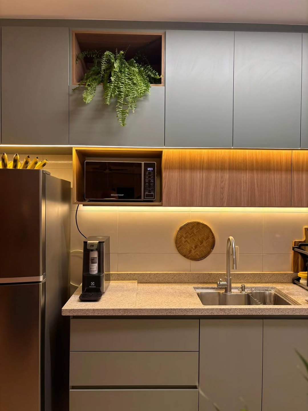 Cozinha sálvia com faixa amadeirada e LED quente